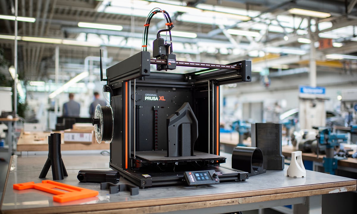 Prusa XL+ large-format 3D printer with 3D printed architectural mockups on a workbench