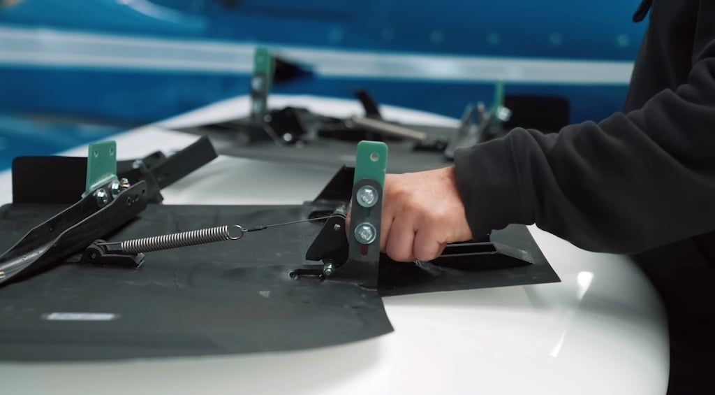 Hands fitting a 3D printed landing gear door to the airframe