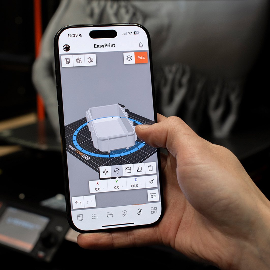 Ein Nutzer, der ein Smartphone mit der EasyPrint-App in der Hand hält und einen Druckvorgang über Printables.com auslöst