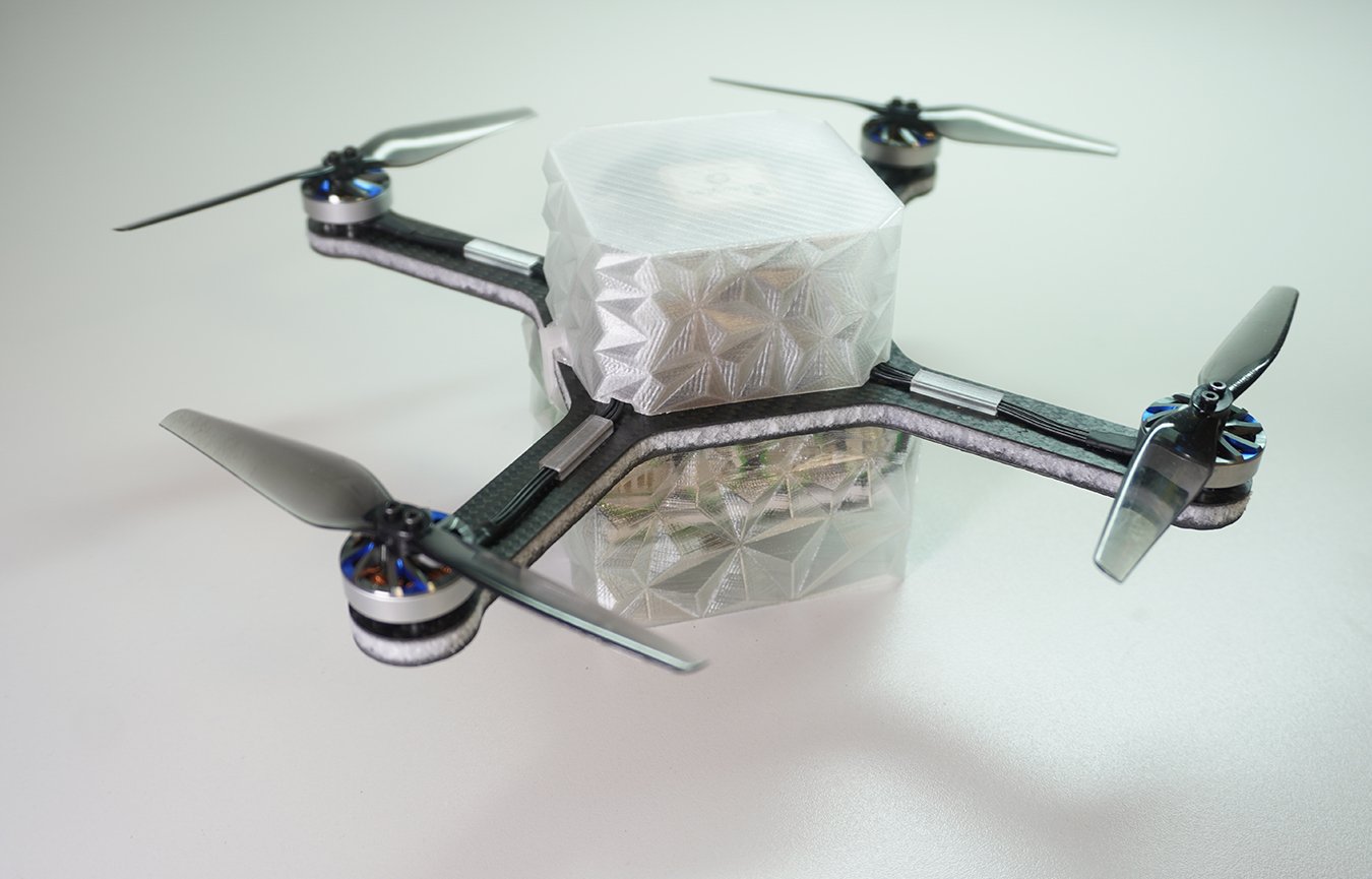 Dron czterowirnikowy z wydrukowaną ramą i półprzezroczystym, fasetowanym korpusem