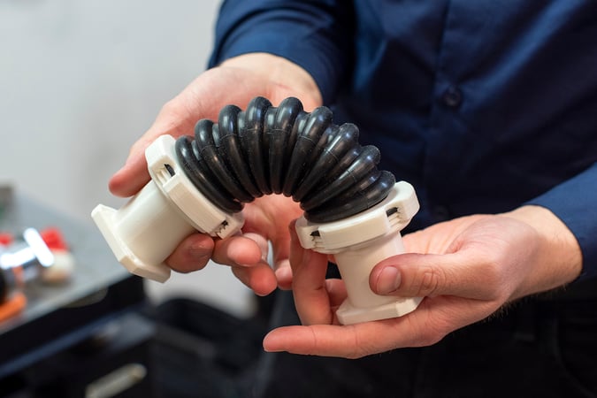 Engineer inspecting high-precision functional end-use 3D printed part in a laboratory