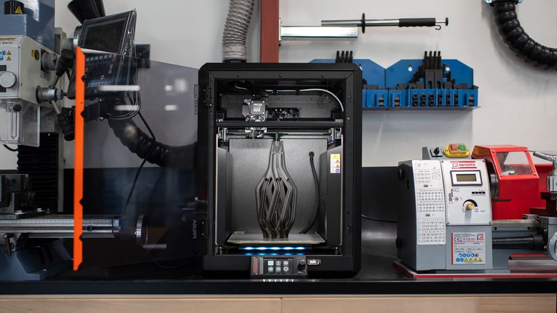 Configuration d'une imprimante 3D montrant plusieurs têtes d'outil et des impressions terminées