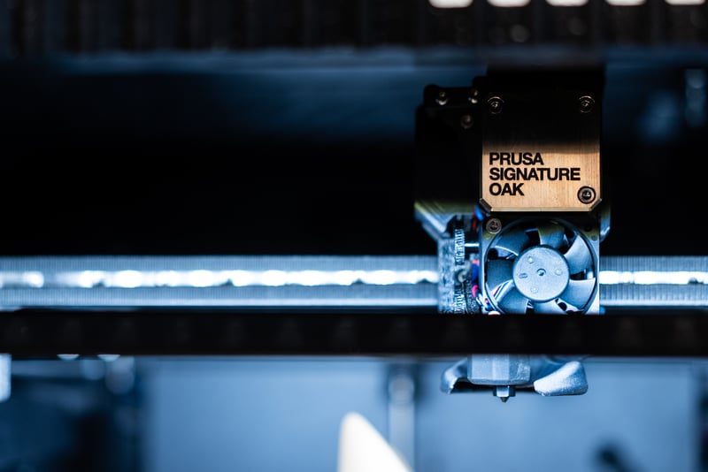 Side door of the Prusa Signature Oak opening to reveal the integrated filament spool holder