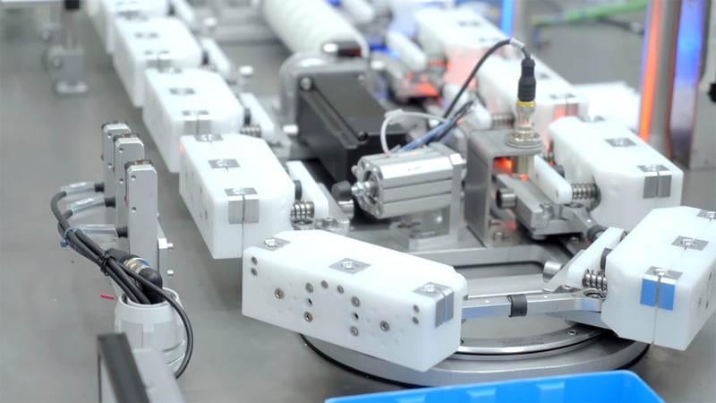 Custom 3D printed robotic gripper claw handling products on an automated EDS Robotics assembly line